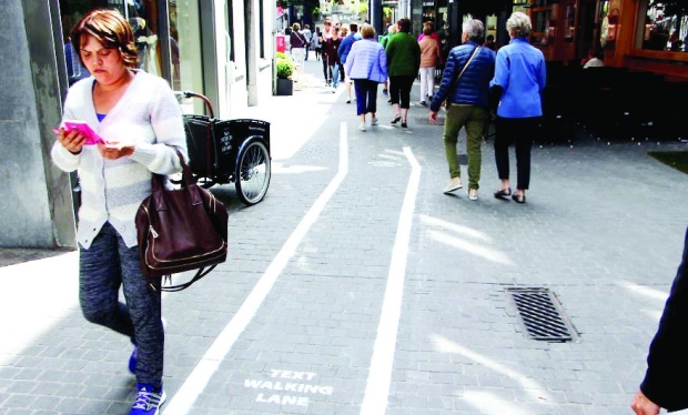 Pedestrians who text while walking are too busy to even notice the lanes and walk in them Pedestrians who text while walking are too busy to even notice the lanes and walk in them